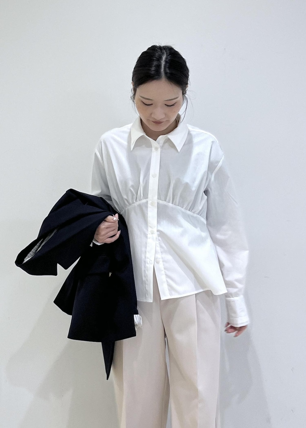 ホワイト系のシャツ/ブラウス、ホワイト系のニット/セーター、ブルー系のテーラードジャケットを着用したレディースの冬コーディネートの10枚目の写真