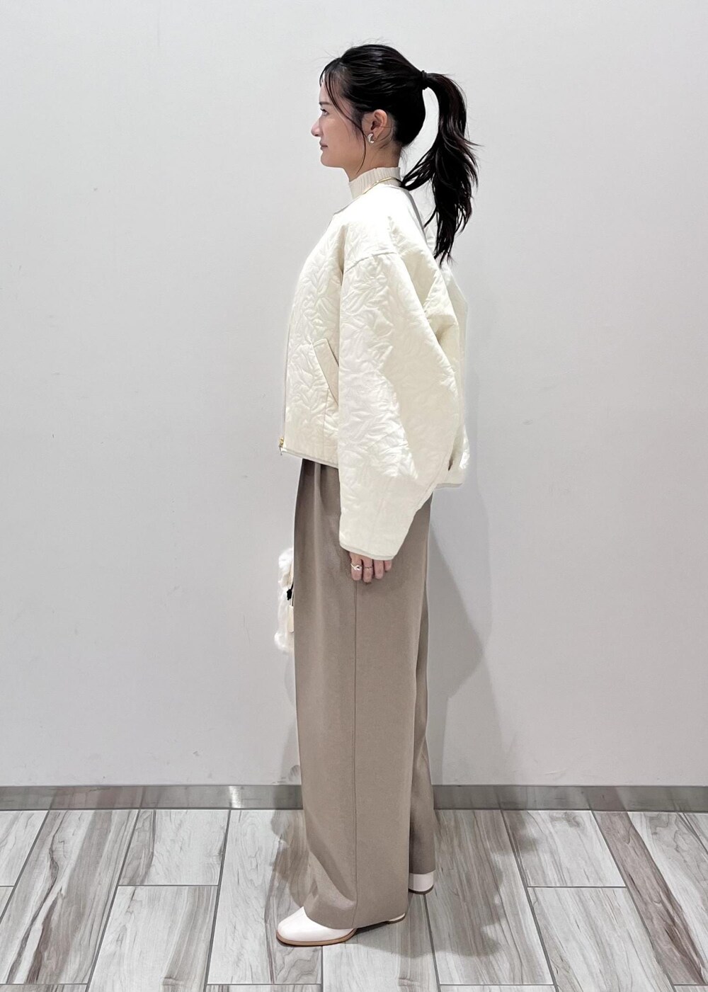 ホワイト系のショルダーバッグ、ホワイト系のブーツ、ホワイト系のブルゾンを着用したレディースの秋コーディネートの3枚目の写真