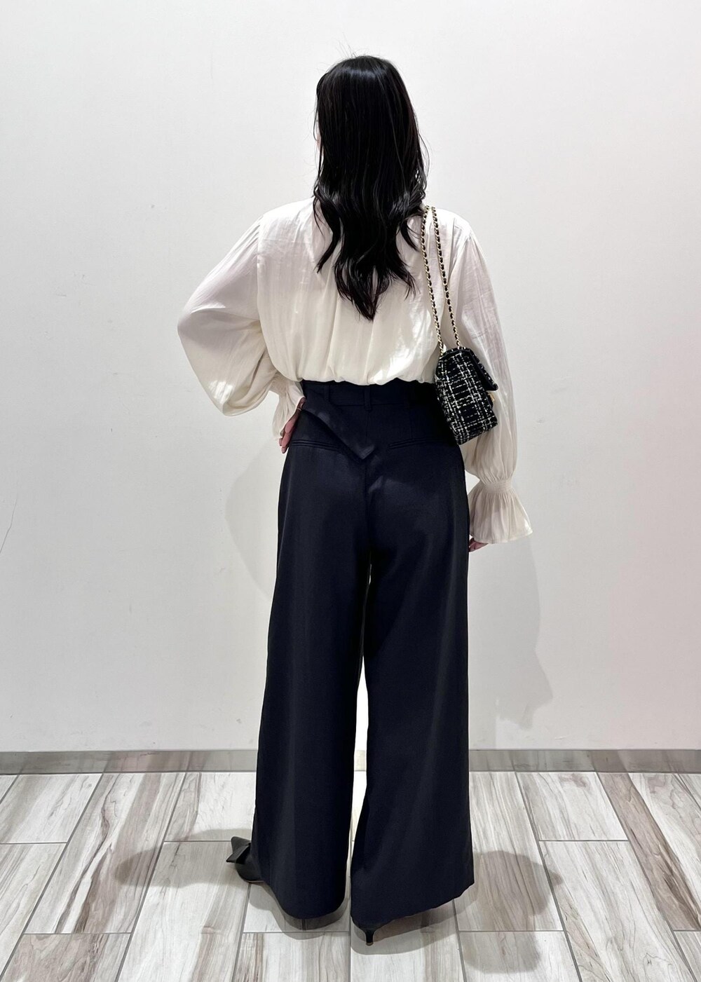 ブラック系のパンプス、ブラック系のショルダーバッグ、ホワイト系のシャツ/ブラウスを着用したレディースの秋コーディネートの2枚目の写真
