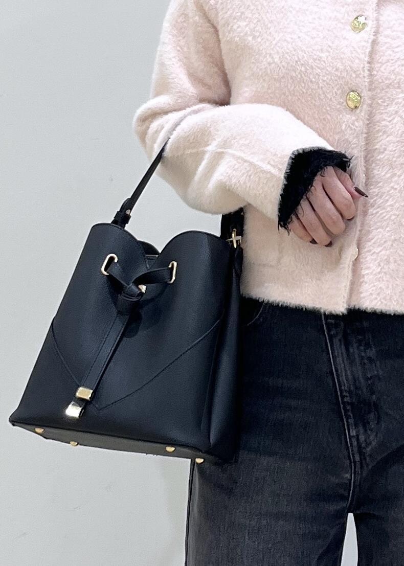 ブラック系のショルダーバッグ、グレー系のデニムパンツ、ピンク系のカーディガン/ボレロを着用したレディースの秋コーディネートの7枚目の写真