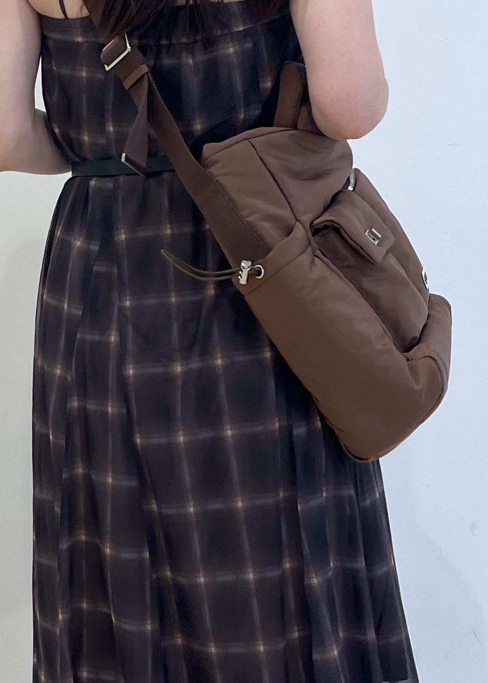 ブルー系のデニムパンツ、ブラウン系のスカート、ブラウン系のキャミソールを着用したレディースの夏コーディネートの7枚目の写真