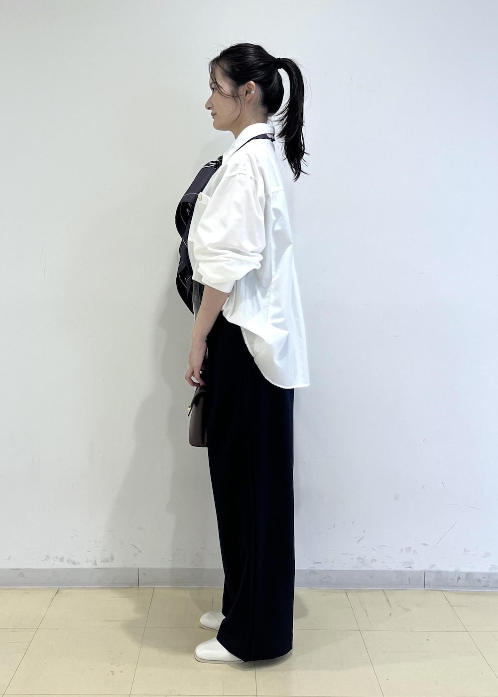 ブルー系のその他パンツ、ブラウン系のショルダーバッグ、ホワイト系のブーツを着用したレディースの秋コーディネートの2枚目の写真