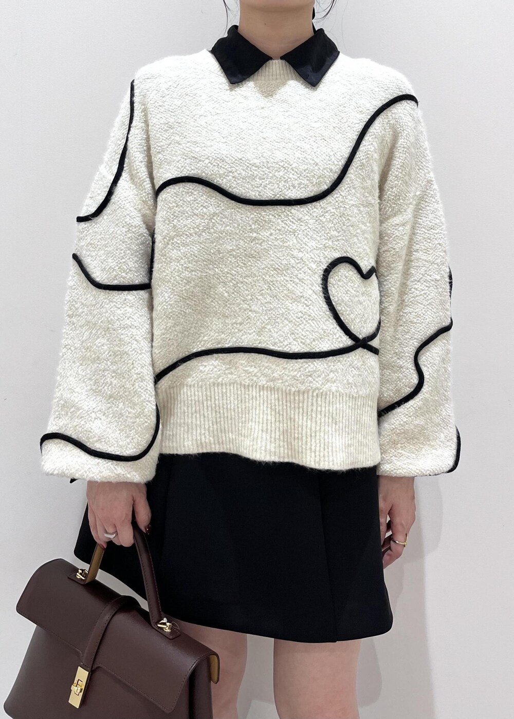 ブラック系のパンプス、ブラウン系のハンドバッグ、ブラック系のシャツ/ブラウスを着用したレディースの秋コーディネートの4枚目の写真