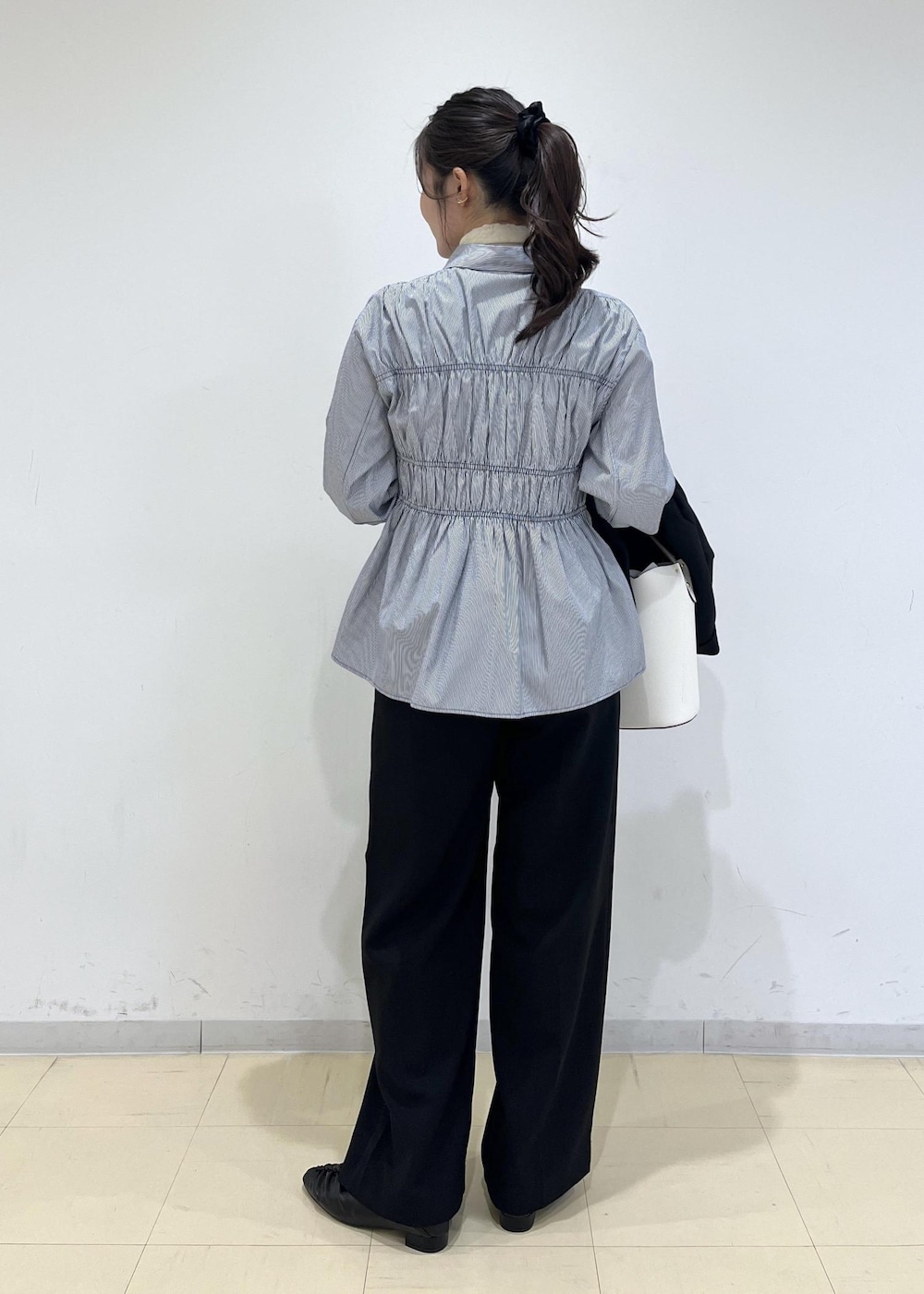 ブラック系のスラックス、ブラック系のテーラードジャケット、ブラック系のパンプスを着用したレディースの秋コーディネートの6枚目の写真