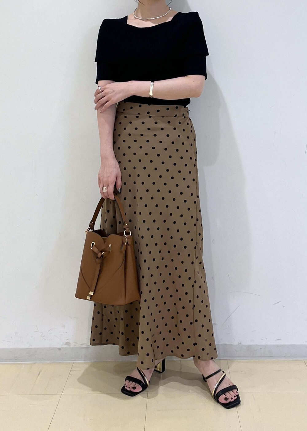 ブラック系のサンダル、ブラウン系のショルダーバッグ、ブラウン系のスカートを着用したレディースの夏コーディネートの9枚目の写真