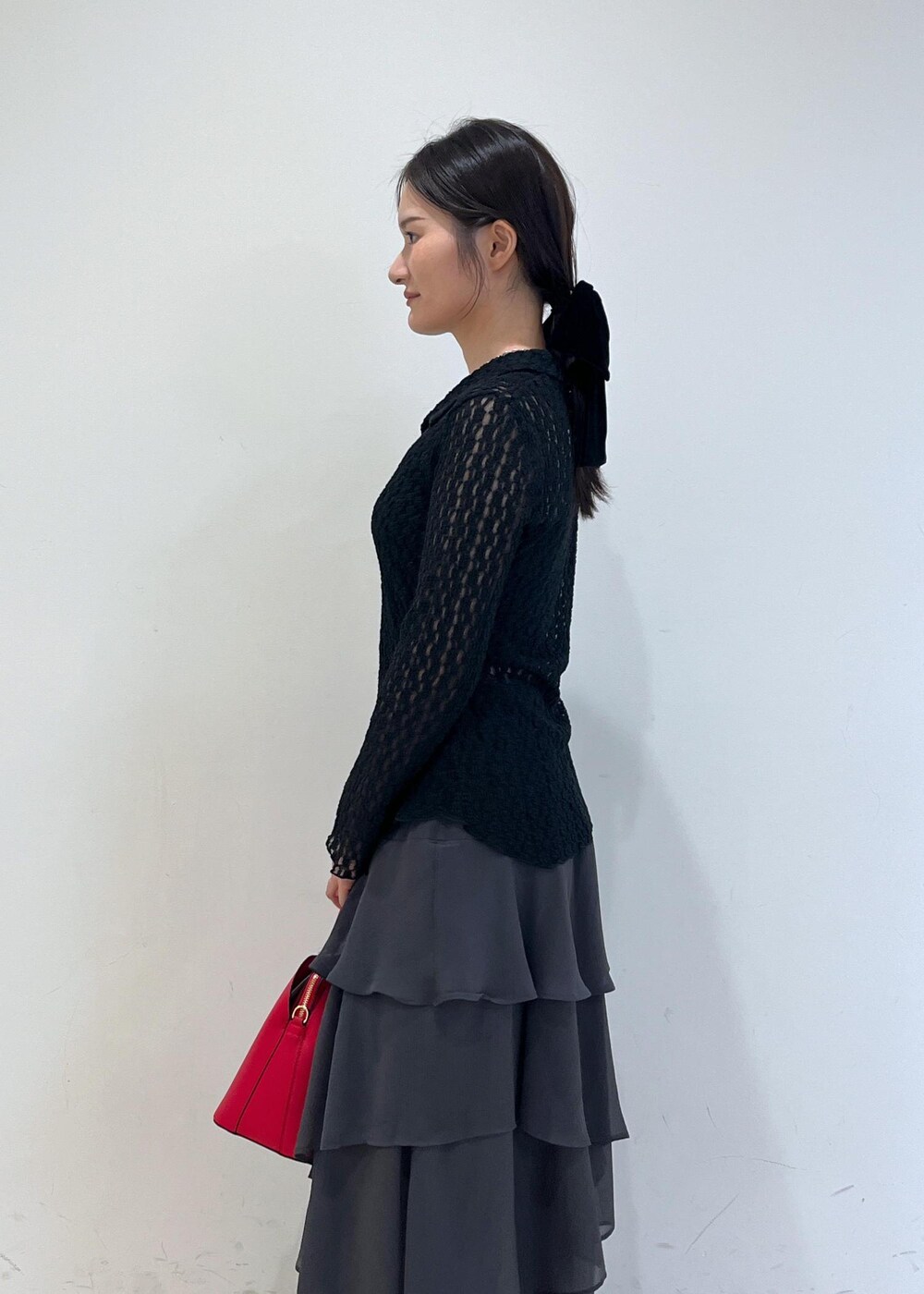 ブラック系のカーディガン/ボレロ、レッド系のボストンバッグ、グレー系のスカートを着用したレディースの秋コーディネートの4枚目の写真