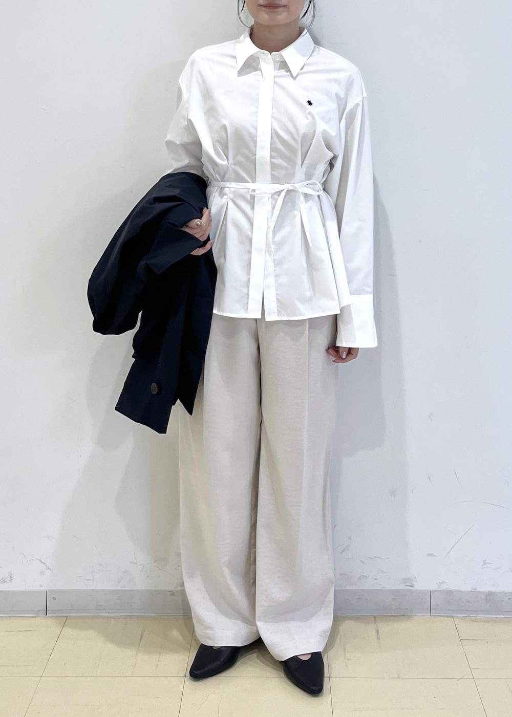 ブラック系のパンプス、ベージュ系のショルダーバッグ、ブルー系のトレンチコートを着用したレディースの春コーディネートの5枚目の写真