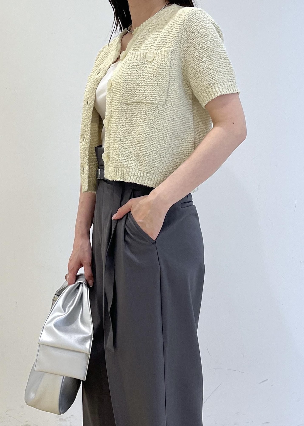 シルバー系のハンドバッグ、シルバー系のパンプス、グリーン系のカーディガン/ボレロを着用したレディースの春コーディネートの8枚目の写真