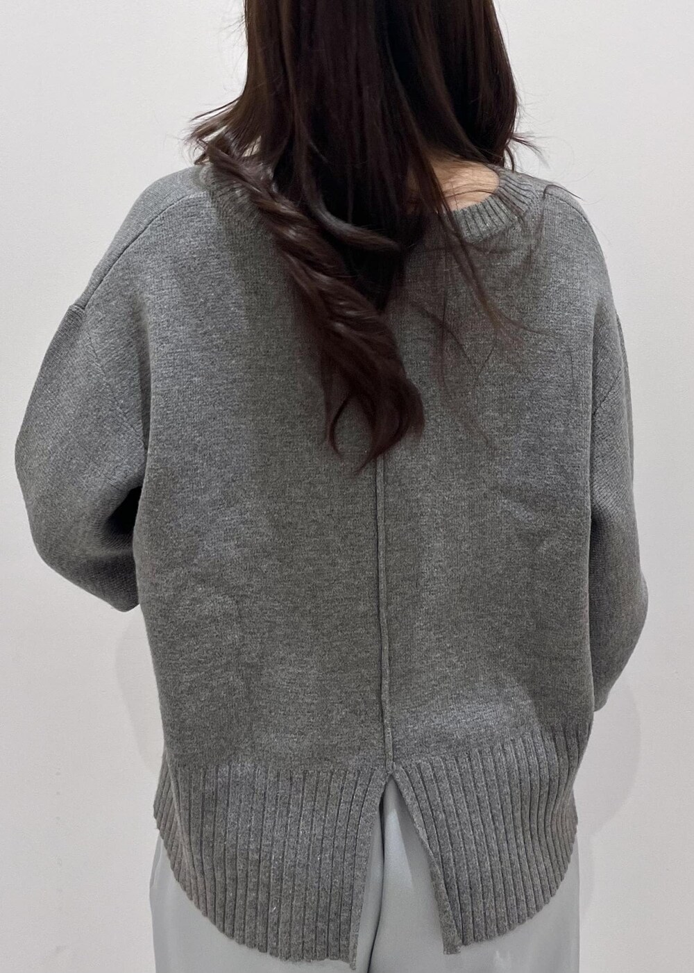 シルバー系のパンプス、シルバー系のショルダーバッグ、ブルー系のスラックスを着用したレディースの秋コーディネートの6枚目の写真