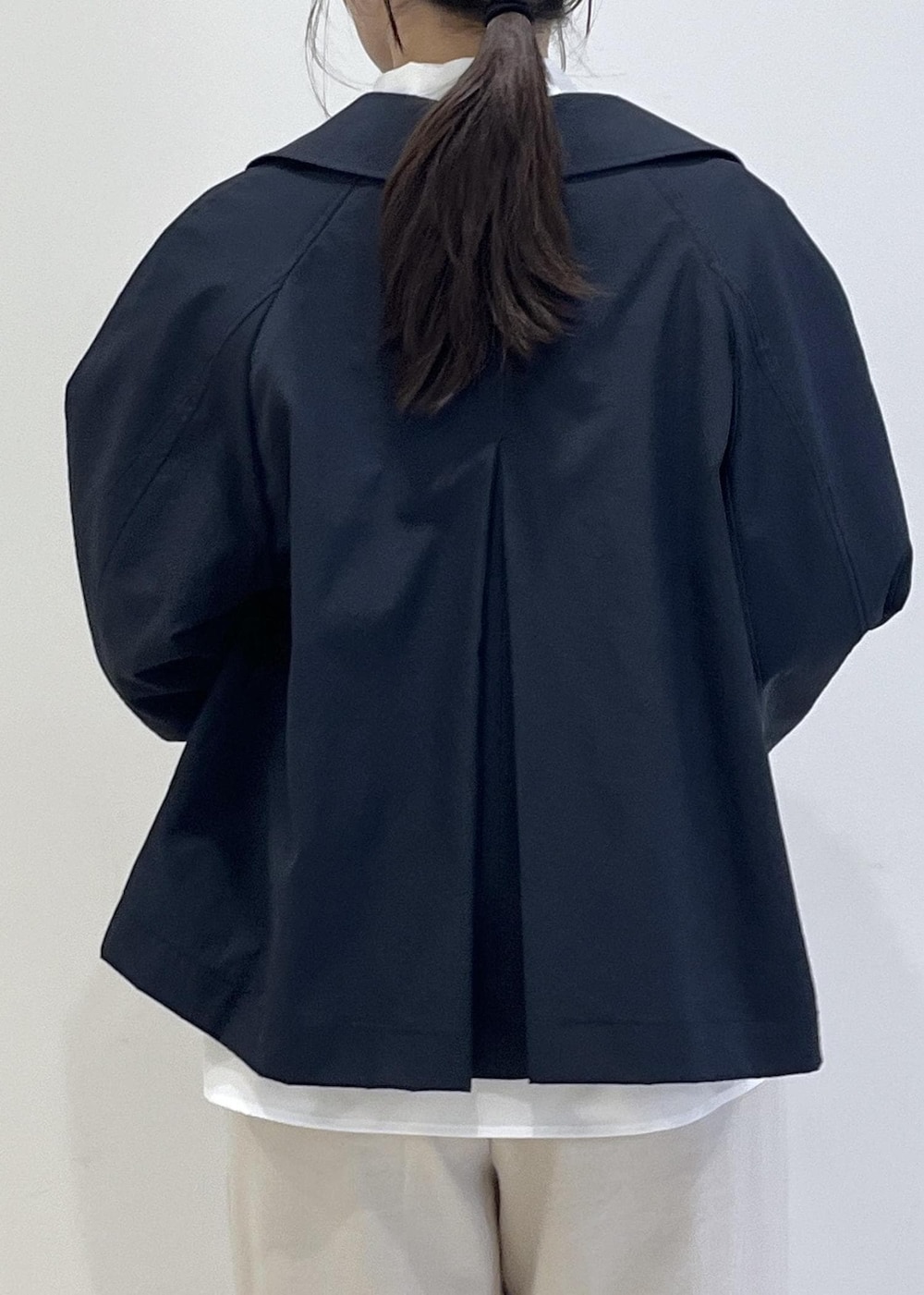 ブラック系のパンプス、ベージュ系のショルダーバッグ、ブルー系のトレンチコートを着用したレディースの春コーディネートの10枚目の写真