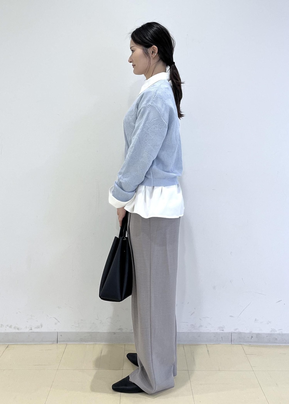 ブラック系のパンプス、グレー系のその他パンツ、ホワイト系のシャツ/ブラウスを着用したレディースの春コーディネートの2枚目の写真