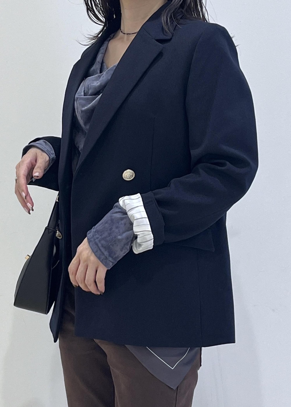 ブラック系のショルダーバッグ、ブルー系のテーラードジャケット、ブルー系のTシャツ/カットソーを着用したレディースの秋コーディネートの9枚目の写真