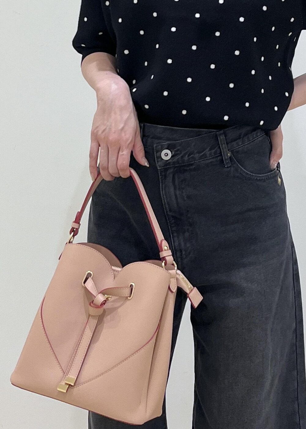 ピンク系のショルダーバッグ、ブラック系のパンプス、ブラック系のニット/セーターを着用したレディースの秋コーディネートの10枚目の写真