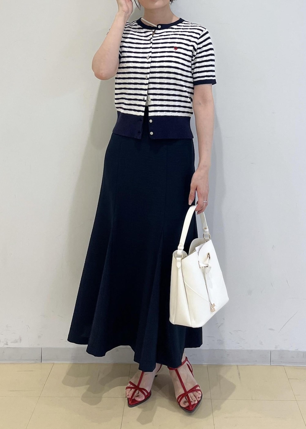 ホワイト系のショルダーバッグ、ホワイト系のキャミソール、レッド系のサンダルを着用したレディースの春コーディネートの6枚目の写真