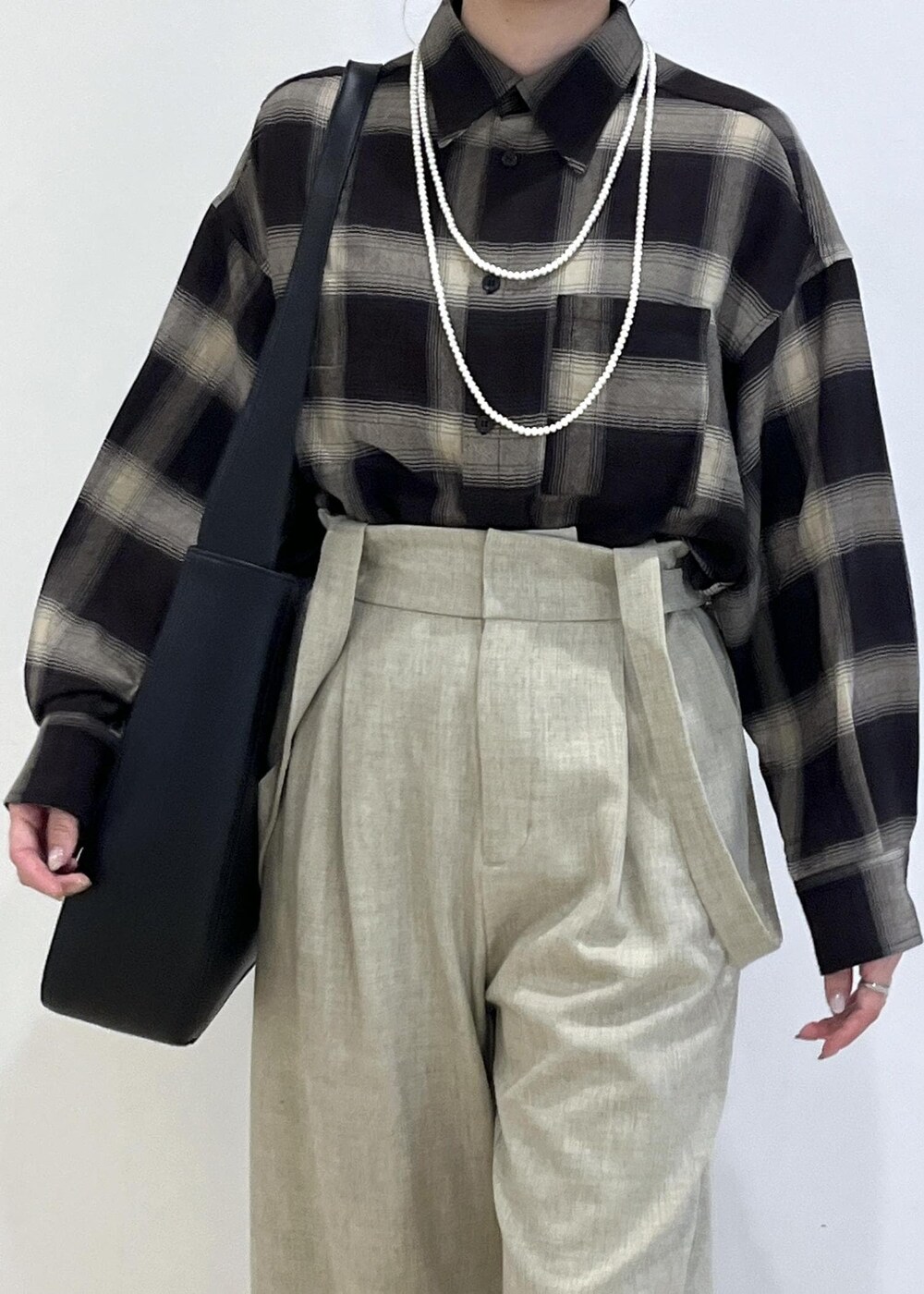 ブラック系のシャツ/ブラウス、ベージュ系のその他パンツ、ブラック系のトートバッグを着用したレディースの秋コーディネートの5枚目の写真