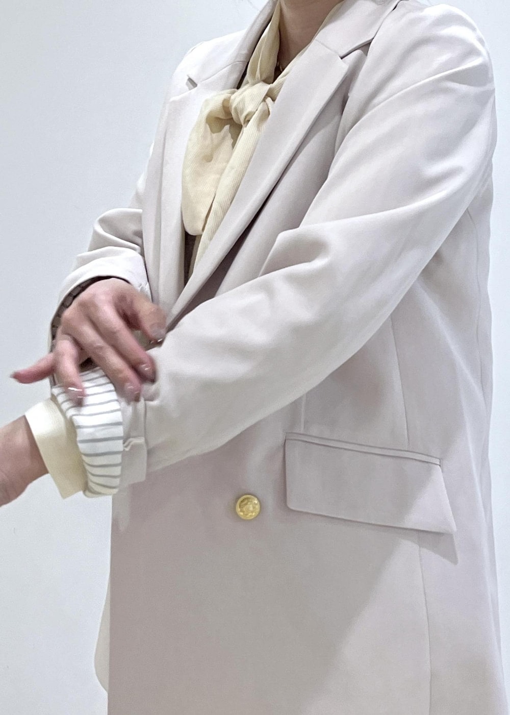 イエロー系のトートバッグ、ベージュ系のローファー、ベージュ系のテーラードジャケットを着用したレディースの冬コーディネートの8枚目の写真