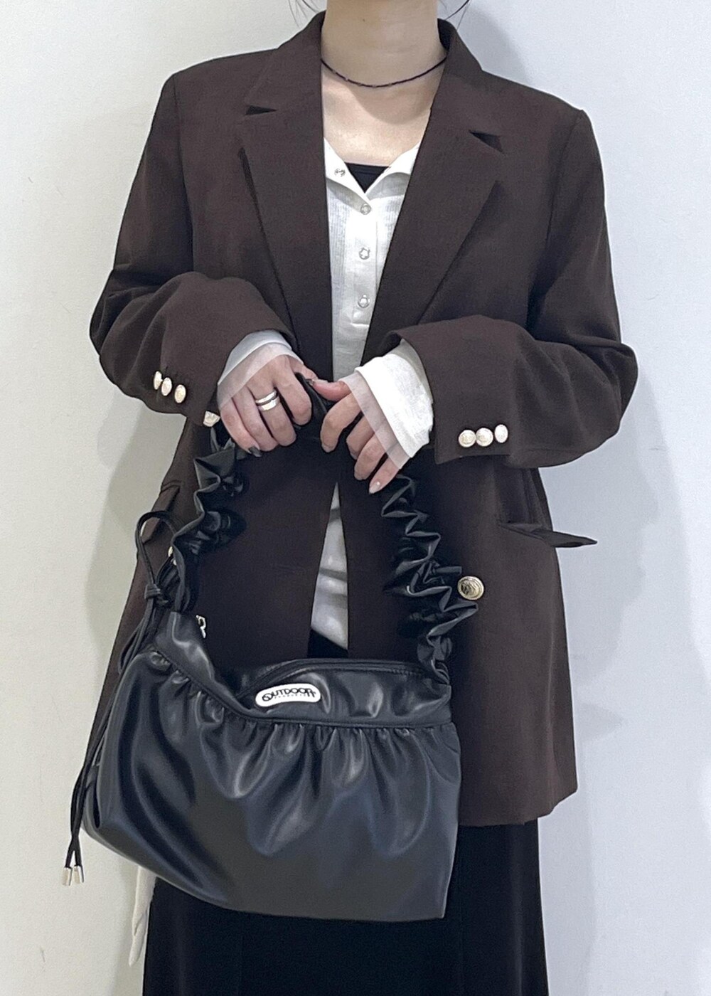 ホワイト系のTシャツ/カットソー、ブラック系のブーツ、ブラック系のスカートを着用したレディースの秋コーディネートの6枚目の写真