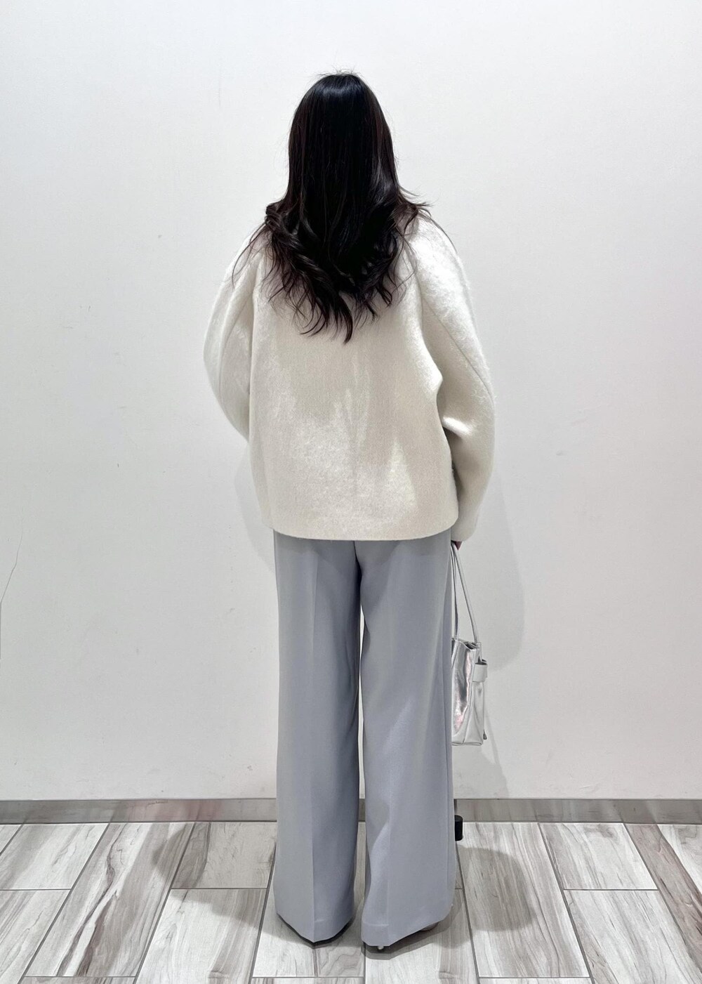 シルバー系のパンプス、シルバー系のショルダーバッグ、ブルー系のスラックスを着用したレディースの秋コーディネートの9枚目の写真