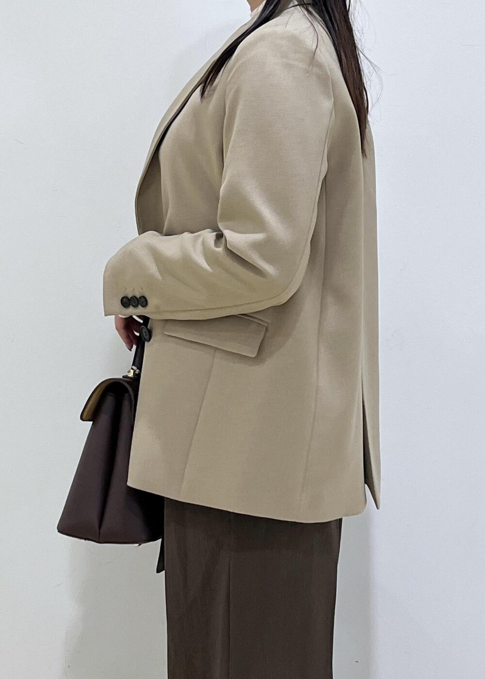 ブラウン系のハンドバッグ、ホワイト系のパンプス、ホワイト系のニット/セーターを着用したレディースの秋コーディネートの9枚目の写真