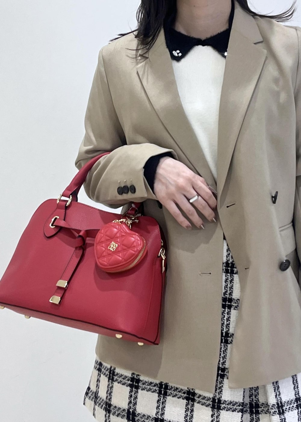 ブラック系のブーツ、ホワイト系のスカート、ホワイト系のニット/セーターを着用したレディースの冬コーディネートの8枚目の写真