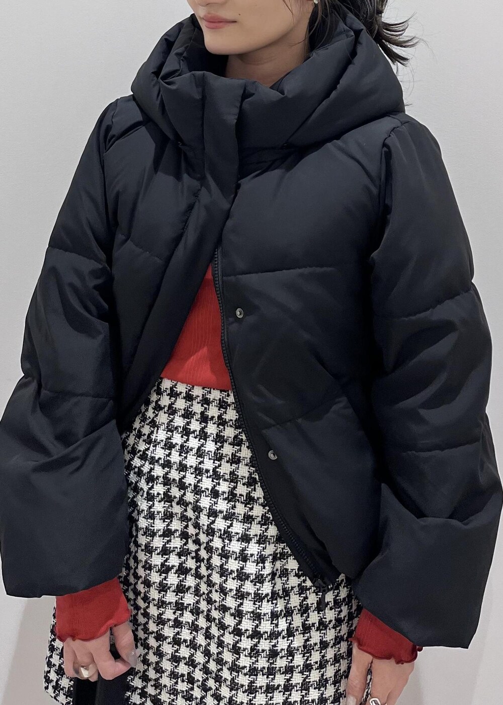 ブラック系のブーツ、ブラック系のスカート、ブラック系のダウンジャケット/コートを着用したレディースの冬コーディネートの4枚目の写真