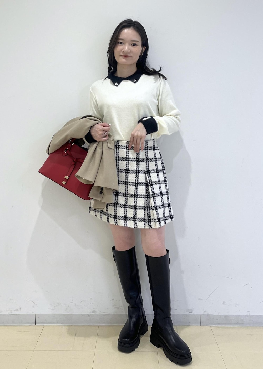 ブラック系のブーツ、ホワイト系のスカート、ホワイト系のニット/セーターを着用したレディースの冬コーディネートの4枚目の写真