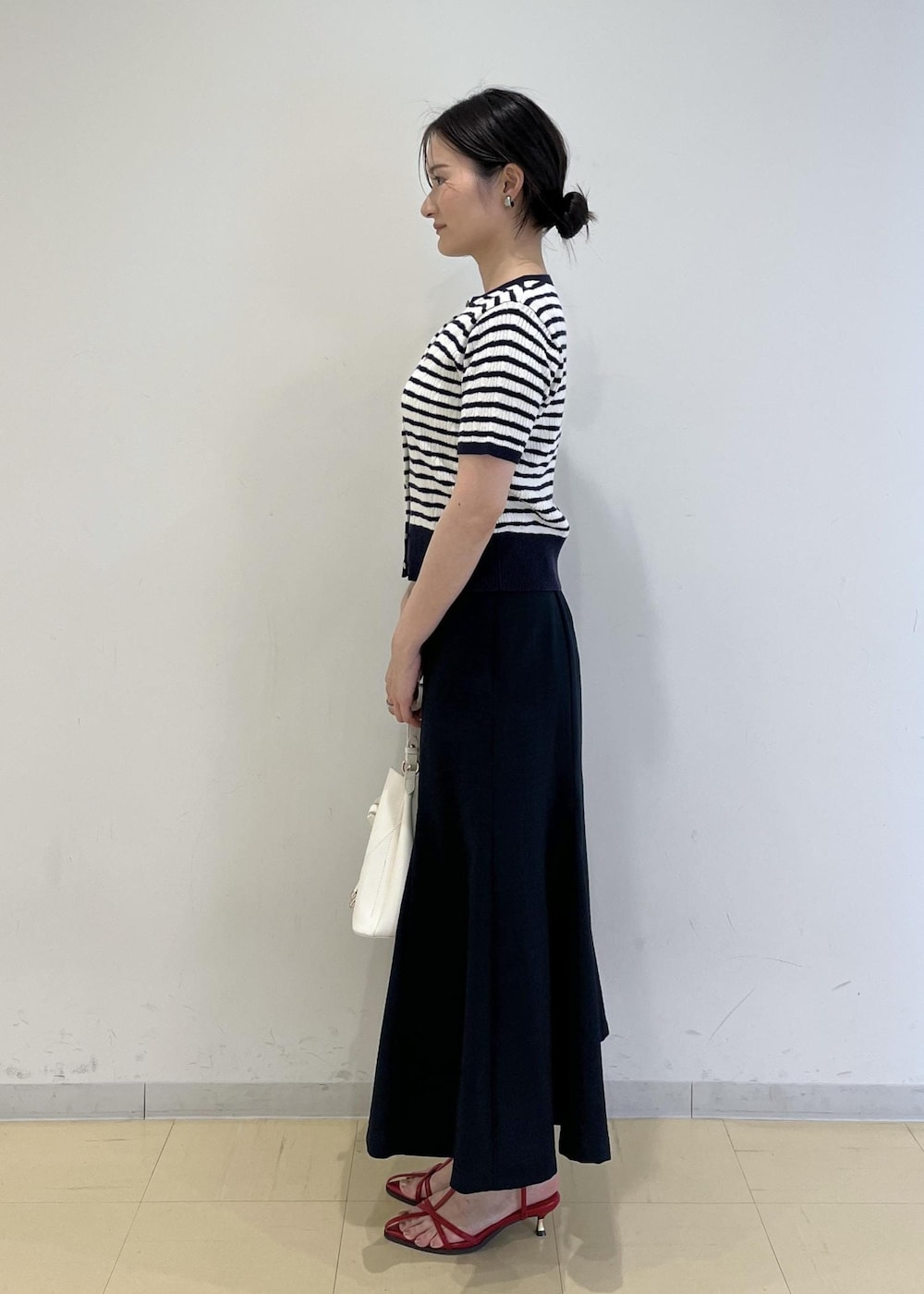 ホワイト系のショルダーバッグ、ホワイト系のキャミソール、レッド系のサンダルを着用したレディースの春コーディネートの4枚目の写真