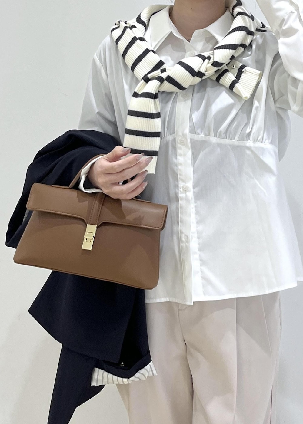 ホワイト系のシャツ/ブラウス、ホワイト系のニット/セーター、ブルー系のテーラードジャケットを着用したレディースの冬コーディネートの8枚目の写真