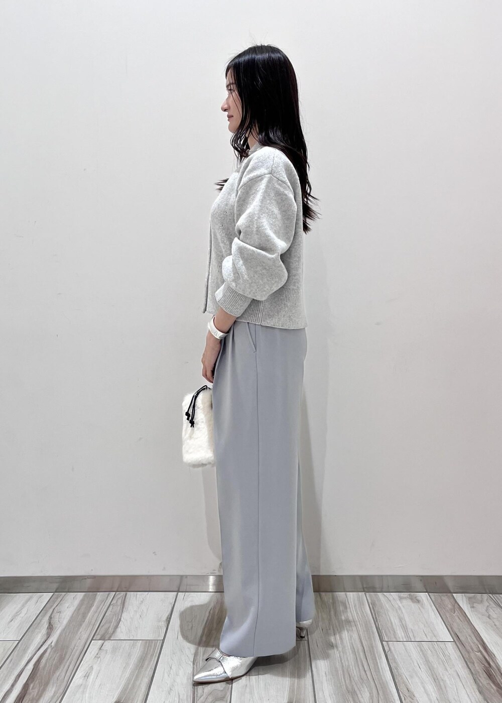 シルバー系のパンプス、ホワイト系のショルダーバッグ、グレー系のカーディガン/ボレロを着用したレディースの秋コーディネートの3枚目の写真