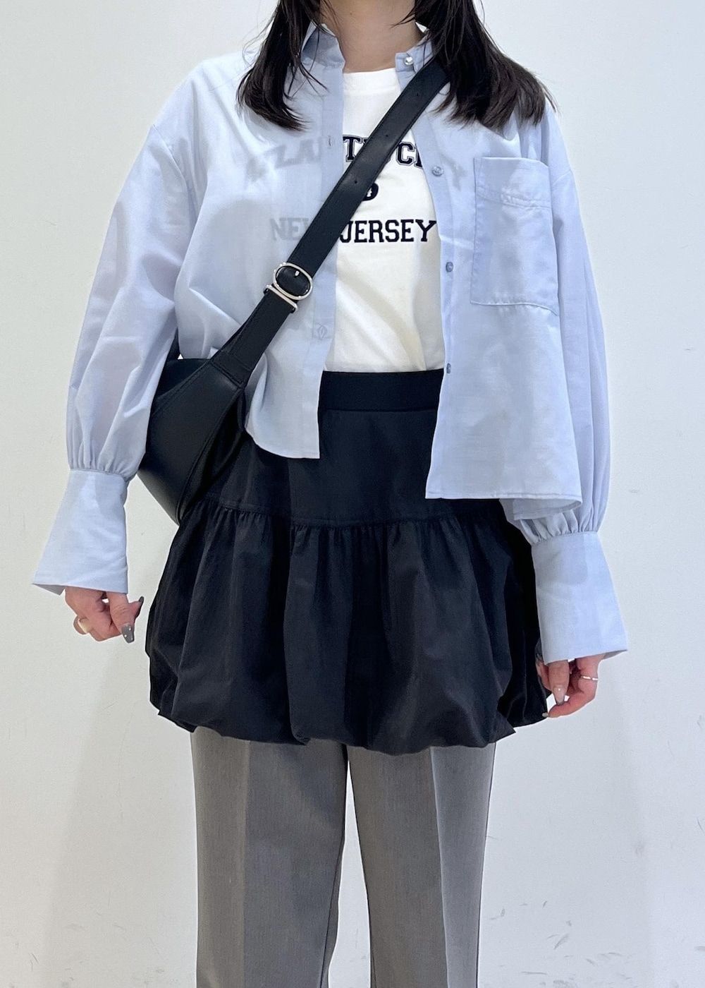 ブラック系のパンプス、ブラック系のスカート、ブルー系のシャツ/ブラウスを着用したレディースの春コーディネートの3枚目の写真