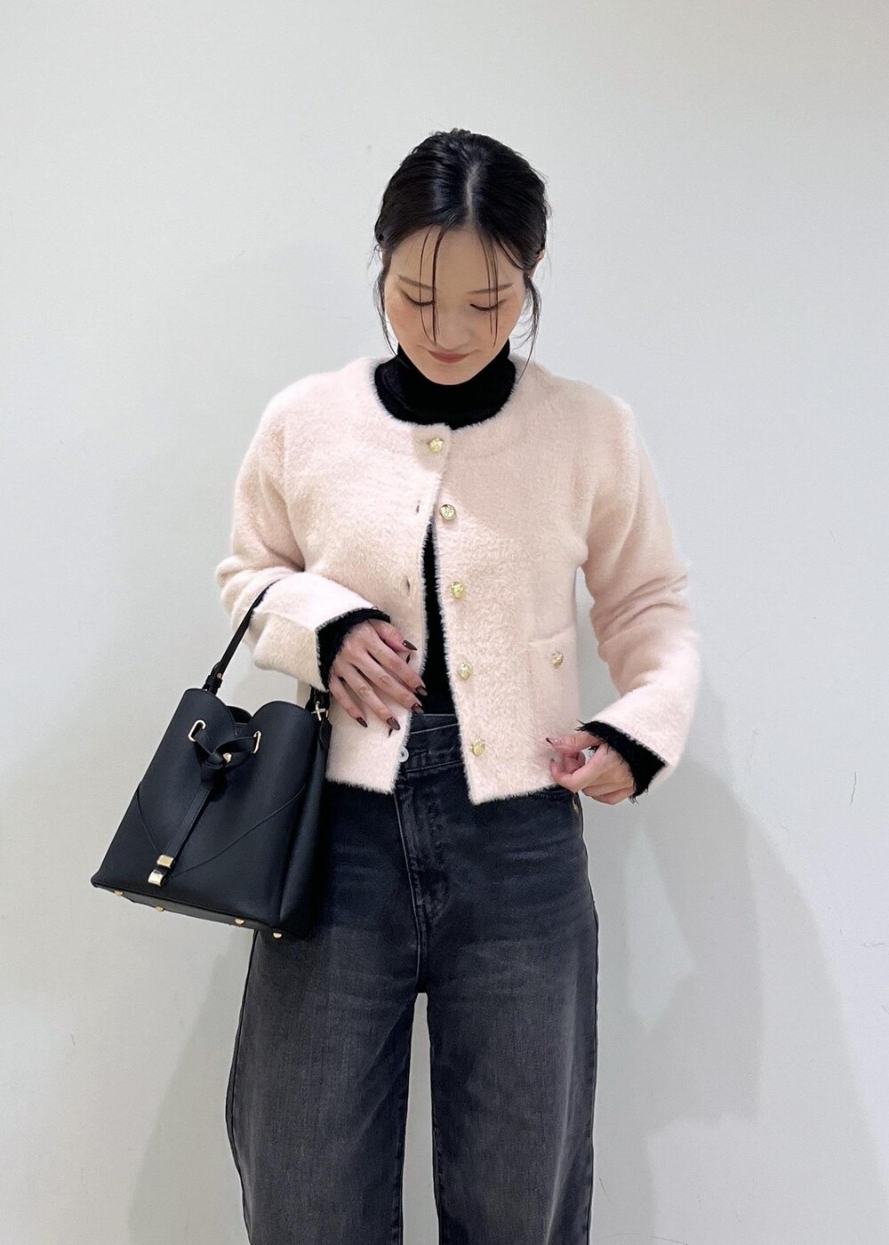 ブラック系のショルダーバッグ、グレー系のデニムパンツ、ピンク系のカーディガン/ボレロを着用したレディースの秋コーディネートの4枚目の写真
