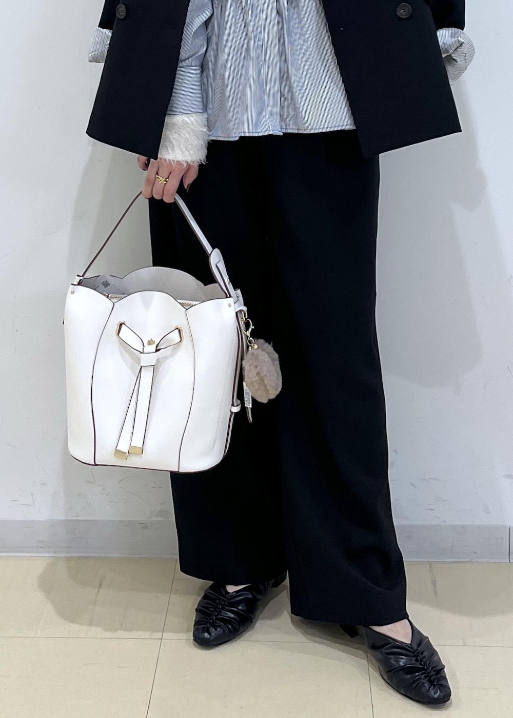 ブラック系のスラックス、ブラック系のテーラードジャケット、ブラック系のパンプスを着用したレディースの秋コーディネートの9枚目の写真