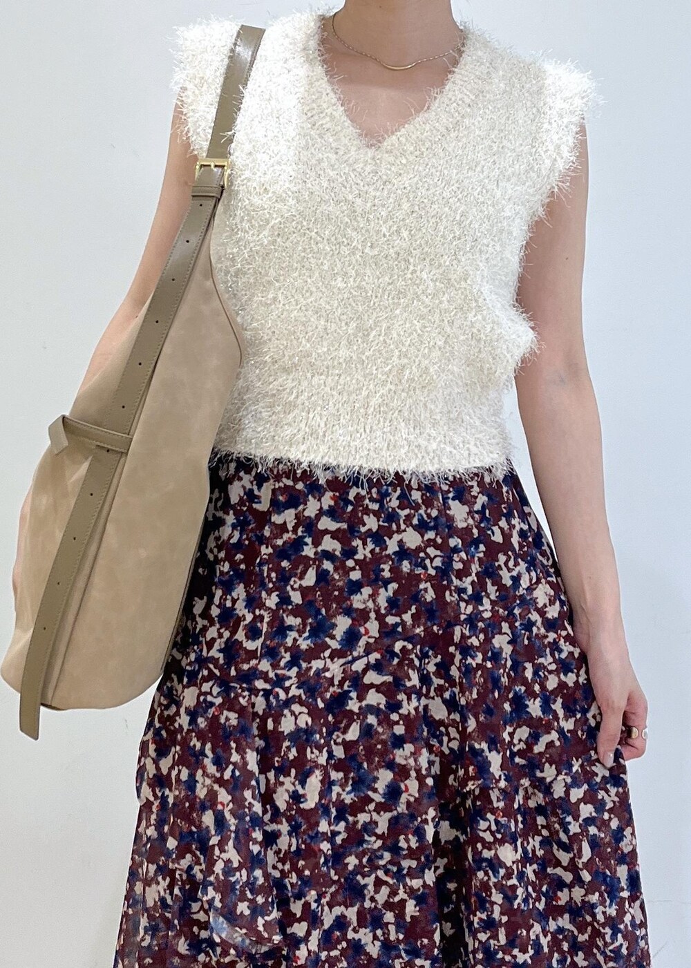 ホワイト系のパンプス、ブラウン系のスカート、ホワイト系のニット/セーターを着用したレディースの秋コーディネートの3枚目の写真