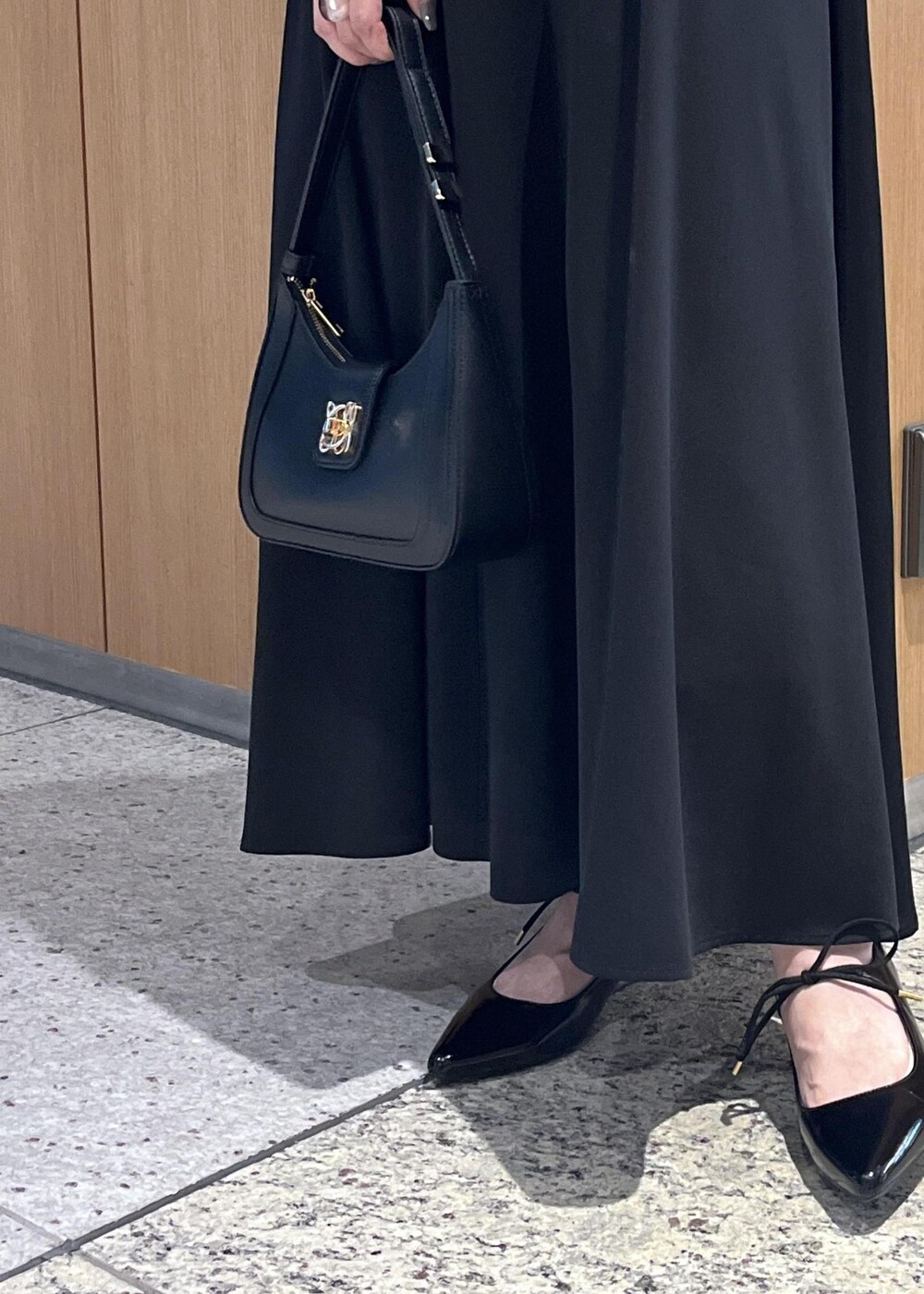 ブラック系のハンドバッグ、ブラック系のパンプス、ブラック系のワンピースを着用したレディースの春コーディネートの10枚目の写真