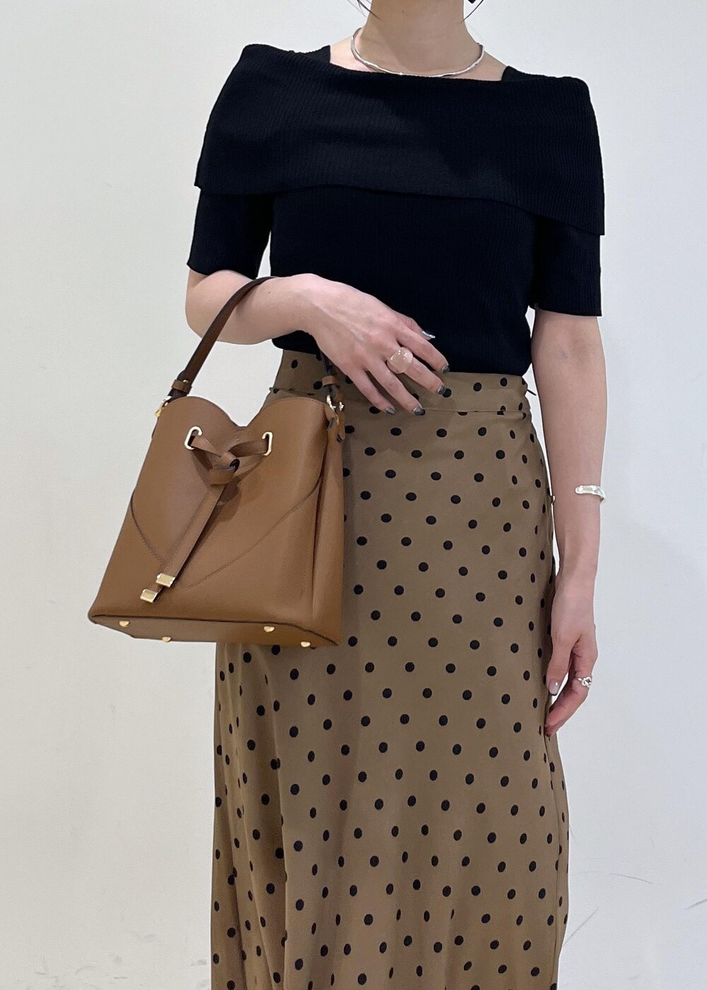 ブラック系のサンダル、ブラウン系のショルダーバッグ、ブラウン系のスカートを着用したレディースの夏コーディネートの8枚目の写真