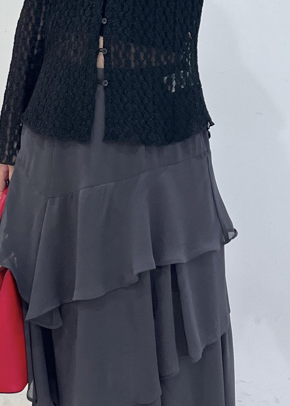 ブラック系のカーディガン/ボレロ、レッド系のボストンバッグ、グレー系のスカートを着用したレディースの秋コーディネートの6枚目の写真