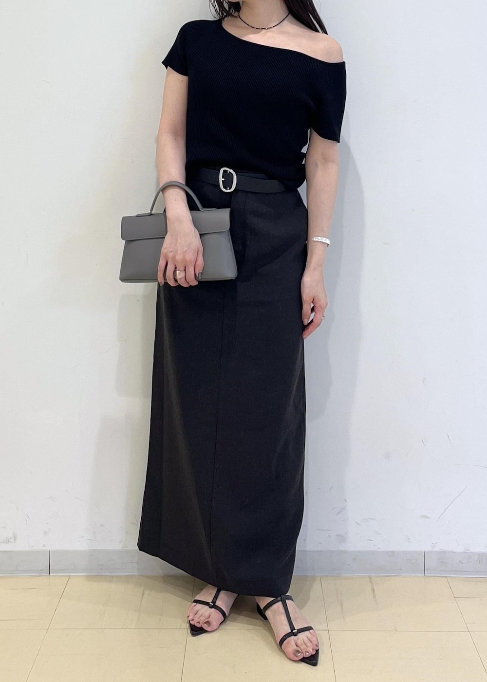 グレー系のショルダーバッグ、グレー系のスカート、ブラック系のニット/セーターを着用したレディースの夏コーディネートの8枚目の写真