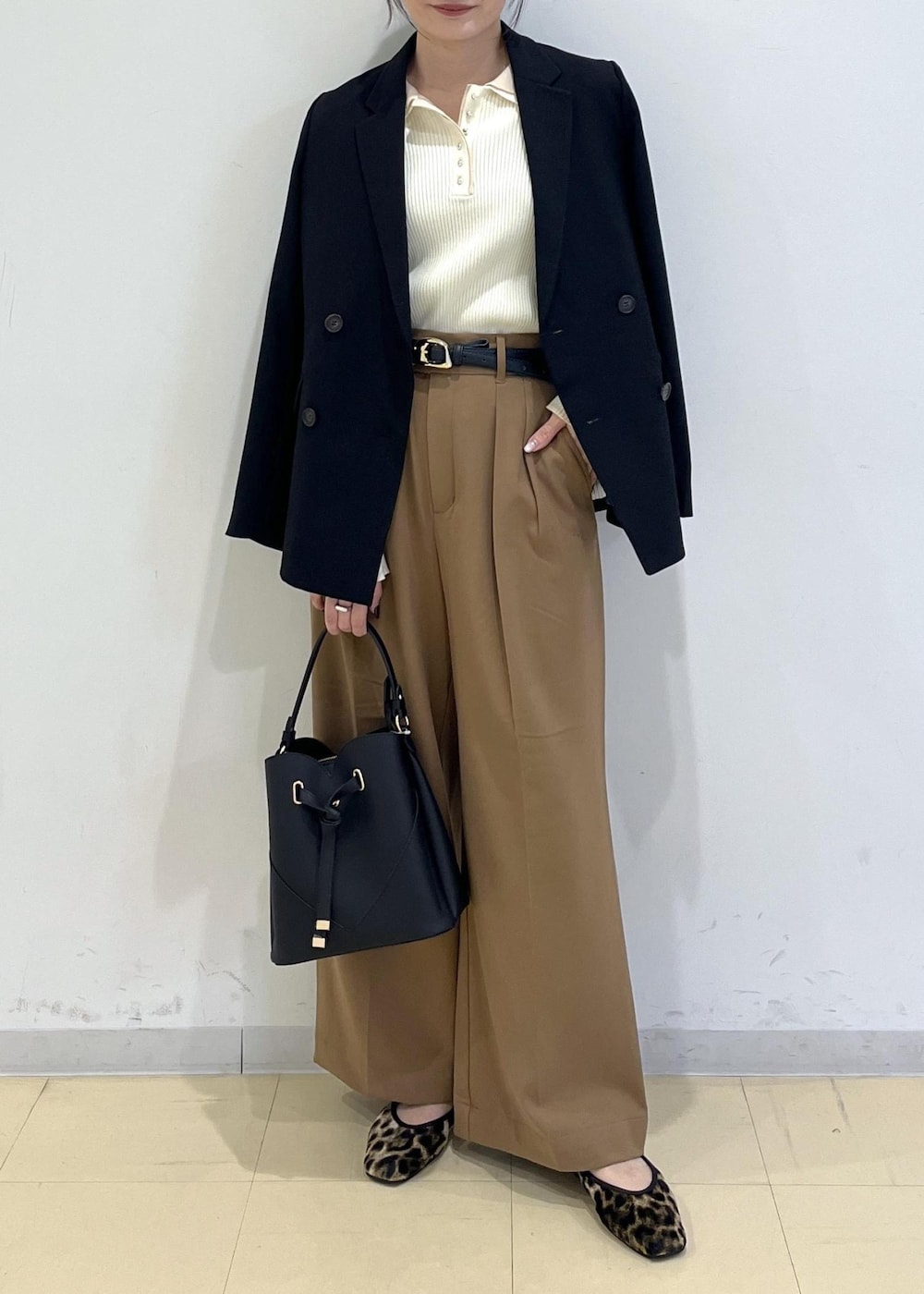 ブラック系のショルダーバッグ、ブラック系のテーラードジャケット、イエロー系のその他パンツを着用したレディースの秋コーディネートの2枚目の写真