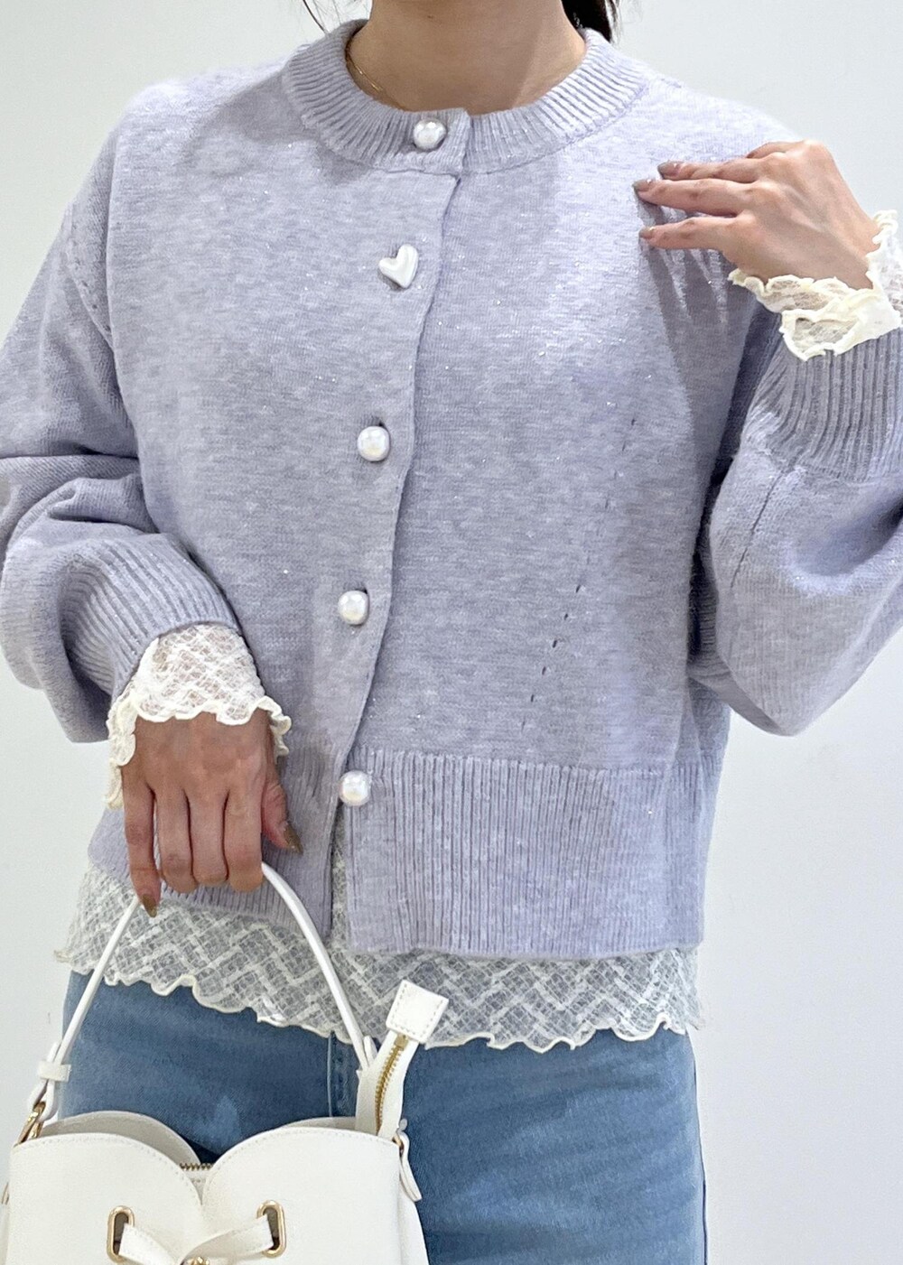 ホワイト系のショルダーバッグ、ホワイト系のパンプス、パープル系のカーディガン/ボレロを着用したレディースの秋コーディネートの6枚目の写真