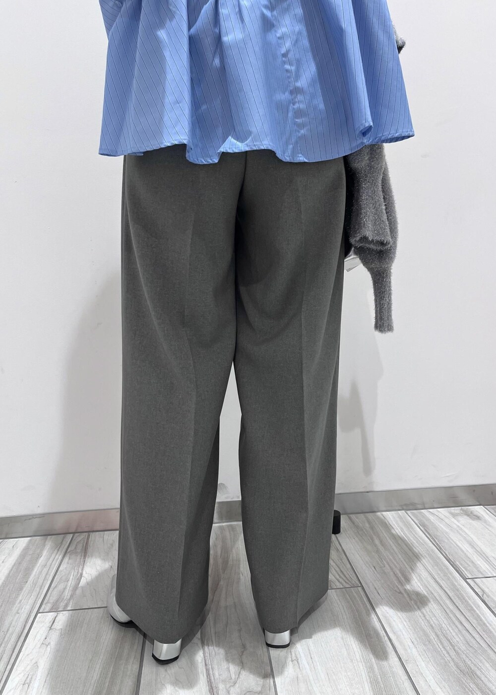 シルバー系のショルダーバッグ、シルバー系のブーツ、グレー系のスラックスを着用したレディースの冬コーディネートの9枚目の写真