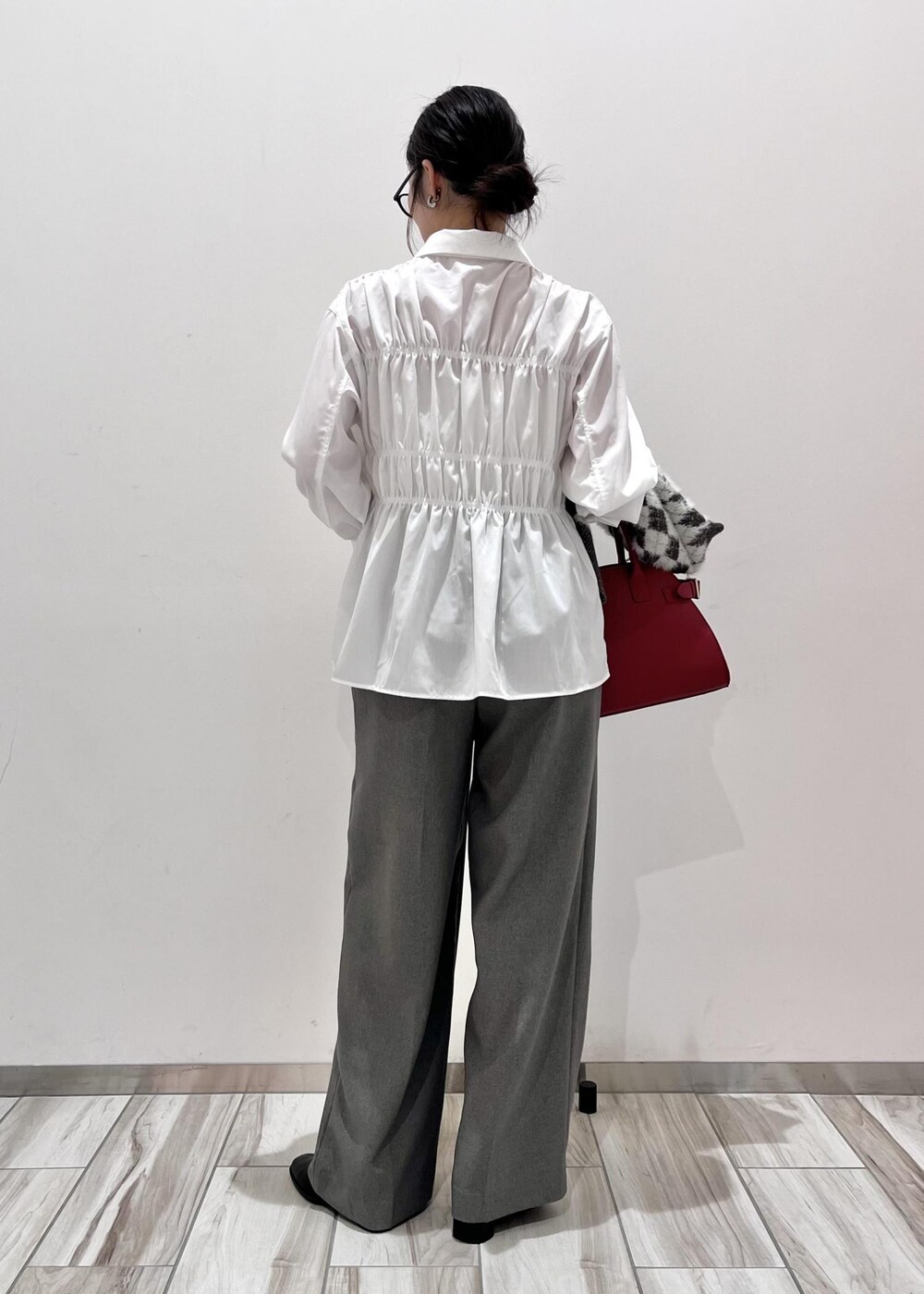 レッド系のトートバッグ、ブラック系のブーツ、ブラック系のカーディガン/ボレロを着用したレディースの秋コーディネートの5枚目の写真