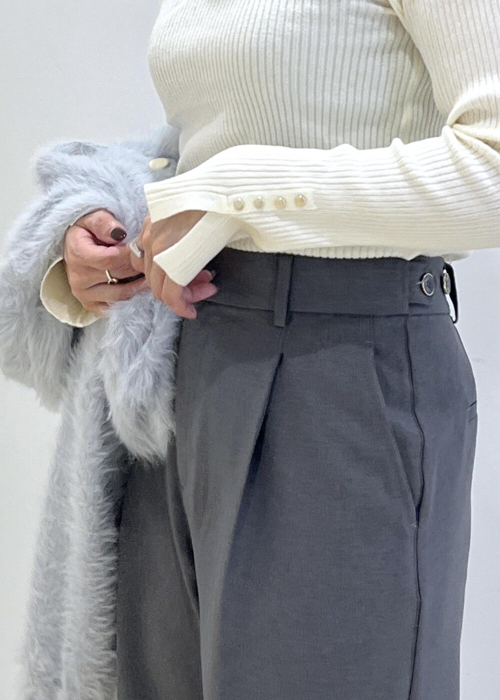 グレー系のスラックス、ホワイト系のパンプス、ブルー系のカーディガン/ボレロを着用したレディースの秋コーディネートの9枚目の写真