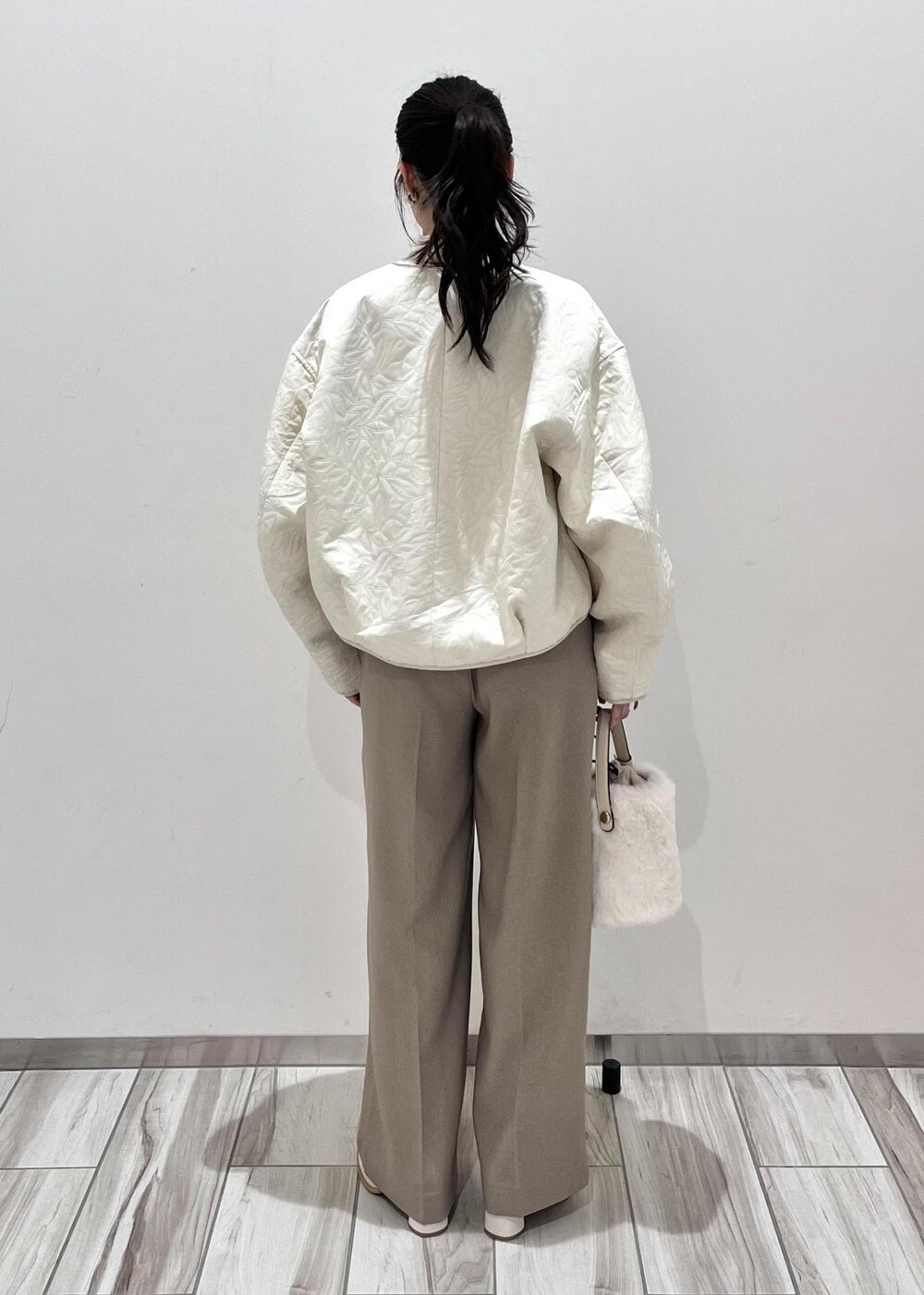ホワイト系のショルダーバッグ、ホワイト系のブーツ、ホワイト系のブルゾンを着用したレディースの秋コーディネートの4枚目の写真