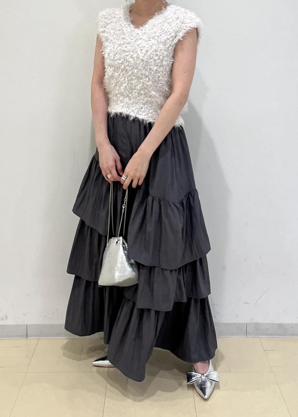 シルバー系のパンプス、シルバー系のショルダーバッグ、グレー系のスカートを着用したレディースの夏コーディネートの5枚目の写真