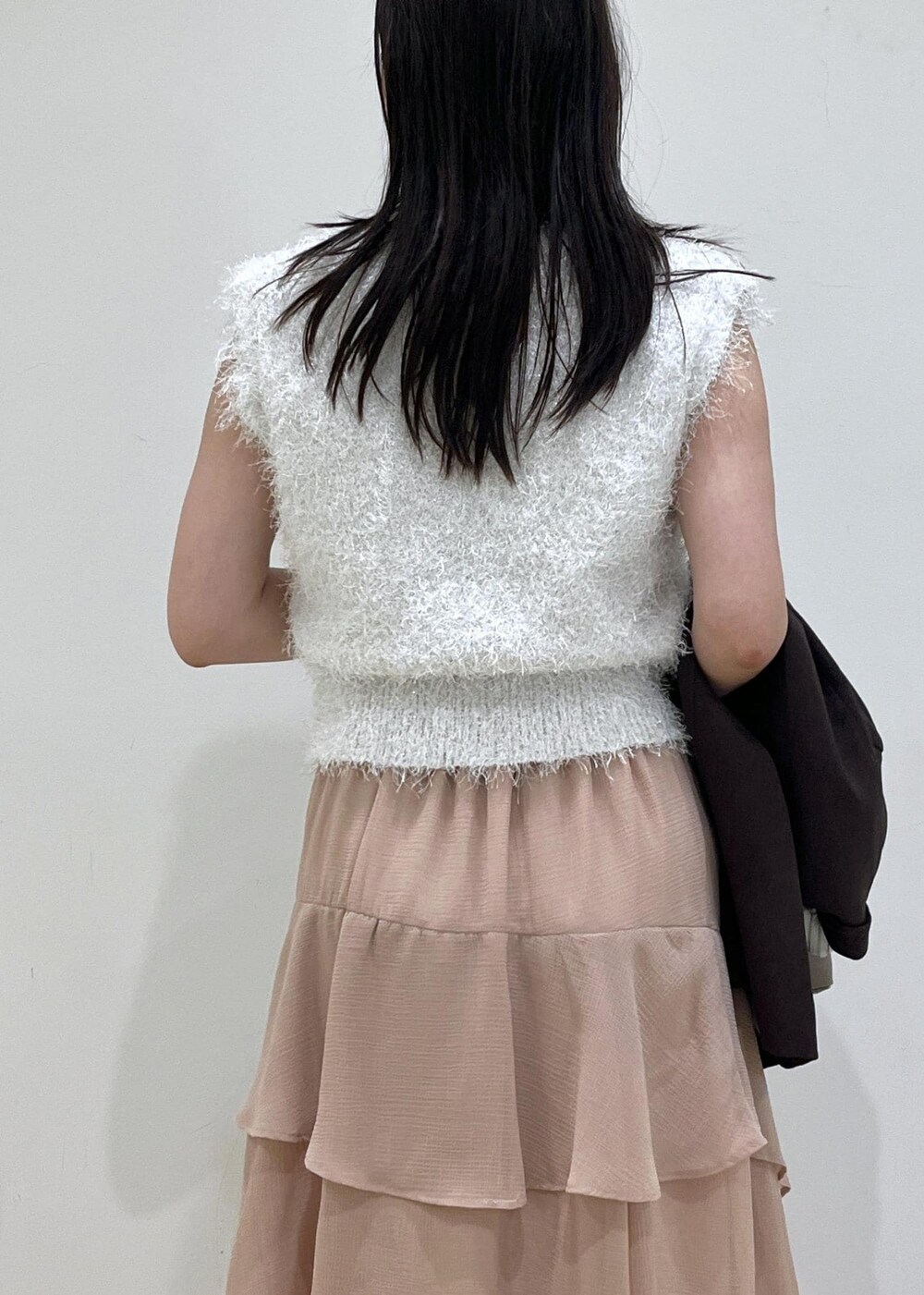 ベージュ系のハンドバッグ、ピンク系のスカート、ホワイト系のニット/セーターを着用したレディースの秋コーディネートの5枚目の写真