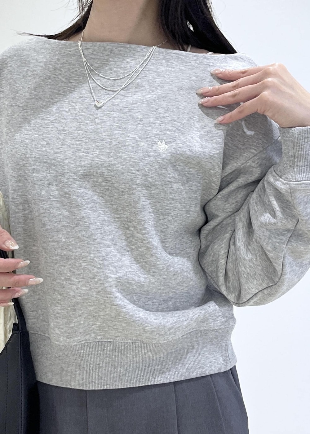 ホワイト系のパンプス、ブラック系のショルダーバッグ、ホワイト系のカーディガン/ボレロを着用したレディースの春コーディネートの5枚目の写真