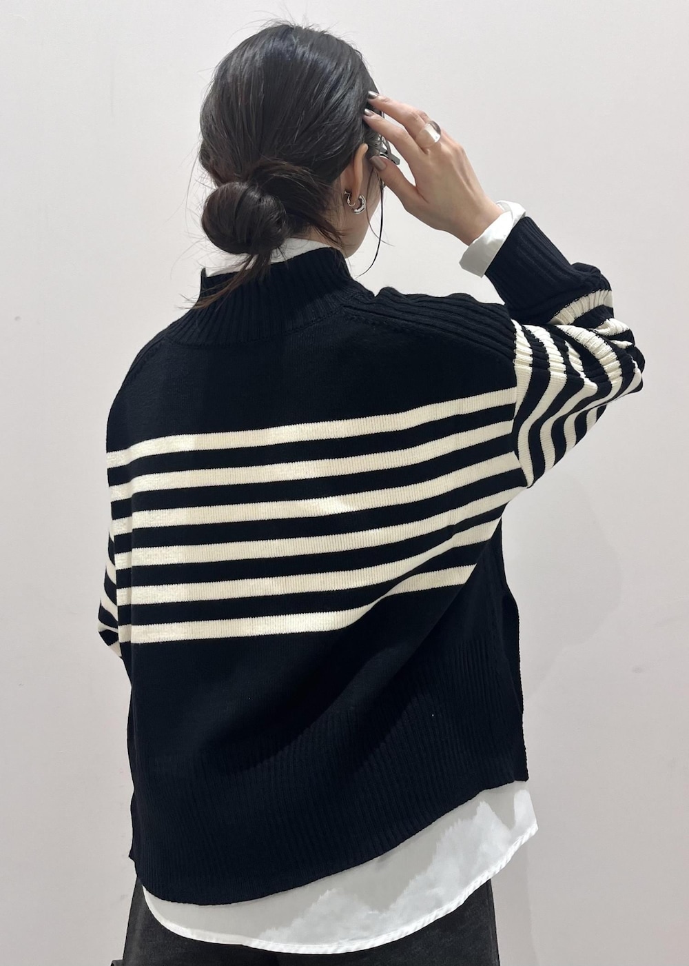 ブラック系のブーツ、ホワイト系のシャツ/ブラウス、ブラック系のニット/セーターを着用したレディースの秋コーディネートの9枚目の写真