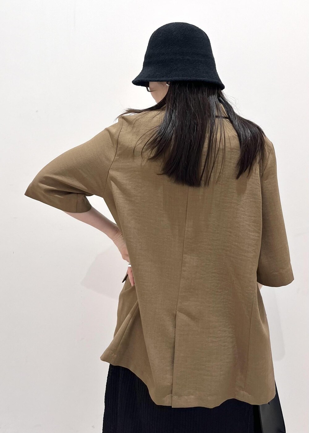 ブラック系のサンダル、ブラック系のハンドバッグ、ブラウン系のテーラードジャケットを着用したレディースの夏コーディネートの6枚目の写真