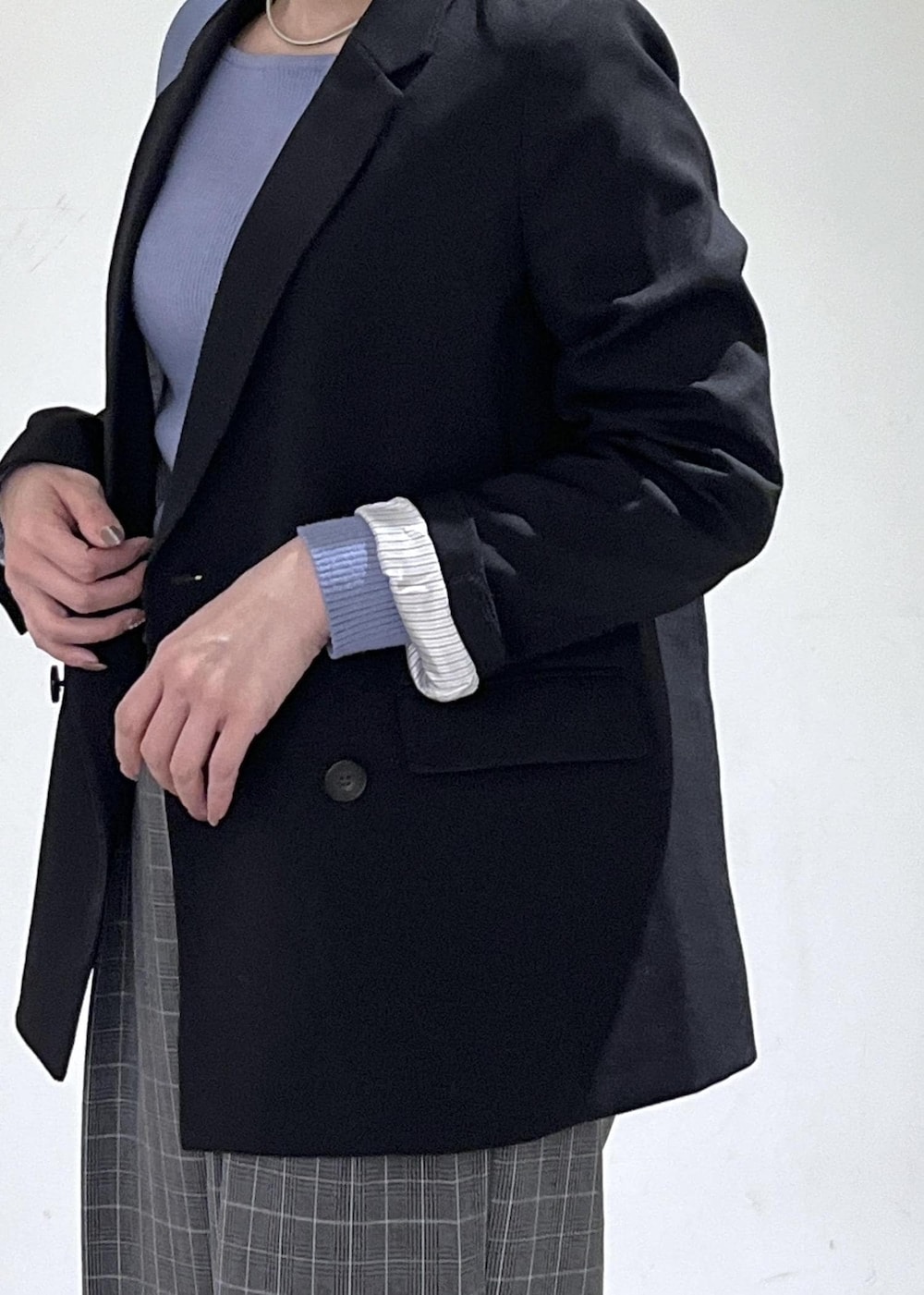 ベージュ系のトートバッグ、ブラック系のテーラードジャケット、ブラック系のチェスターコートを着用したレディースの冬コーディネートの5枚目の写真