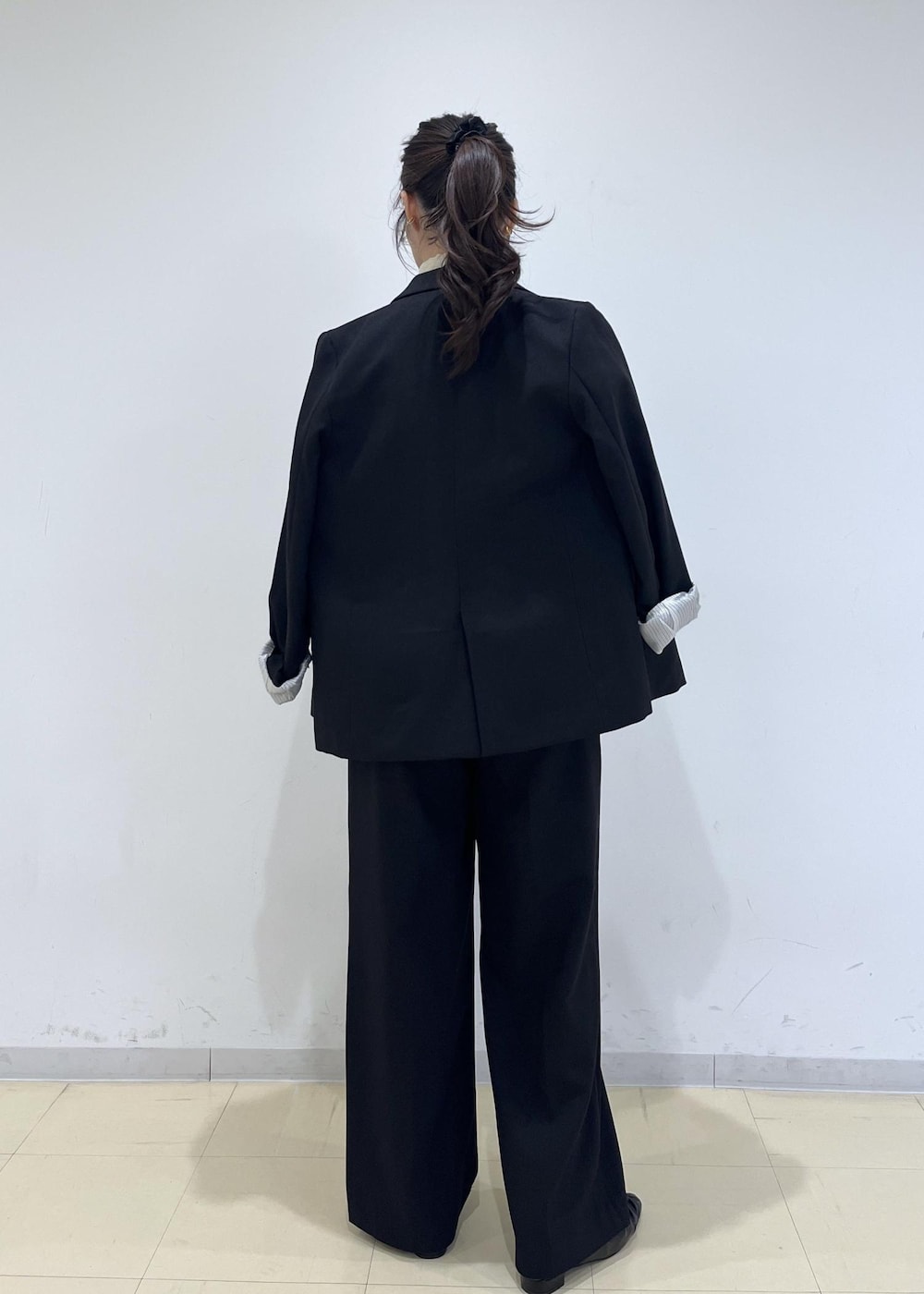 ブラック系のスラックス、ブラック系のテーラードジャケット、ブラック系のパンプスを着用したレディースの秋コーディネートの8枚目の写真